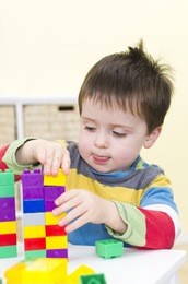 young boy plays with connecting bricks