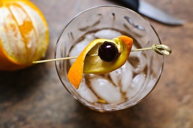 an amarena cherry garnishes an old fashioned cocktail.