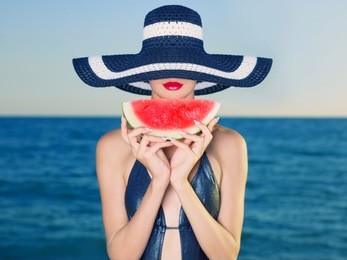 young stylish lady in a hat at sea with watermelon