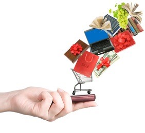 modern mobile phone in the hand with lots of goods isolated on white (e-shopping and sale concept)