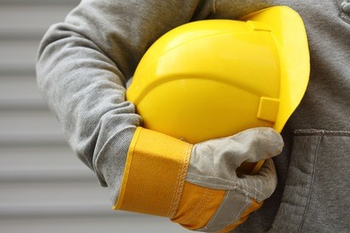 man holding yellow helmet close up