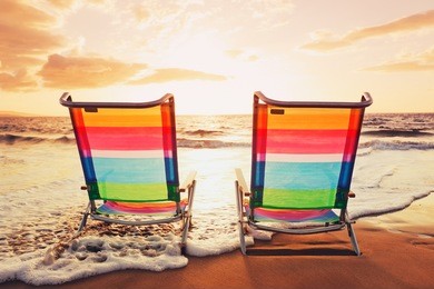 hawaiian vacation sunset concept, two beach chairs at sunset