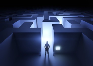 business challenge - a businessman at the entrance to a maze.