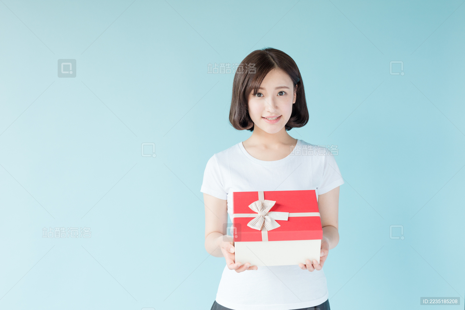 站在蓝色背景前的年轻女生