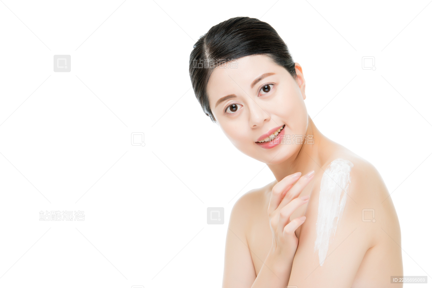 黑发亚洲女性展示漂亮的微笑 因为化妆水让肌肤更有光泽和光泽隔绝在白色背景。时尚美容和健康理念。