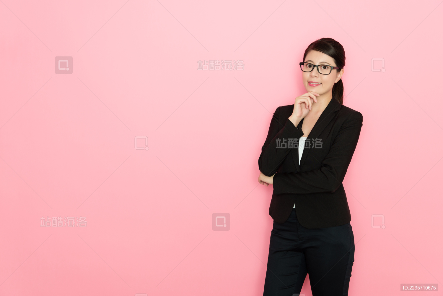 自信专业的女商人站在粉红色背景面对相机。