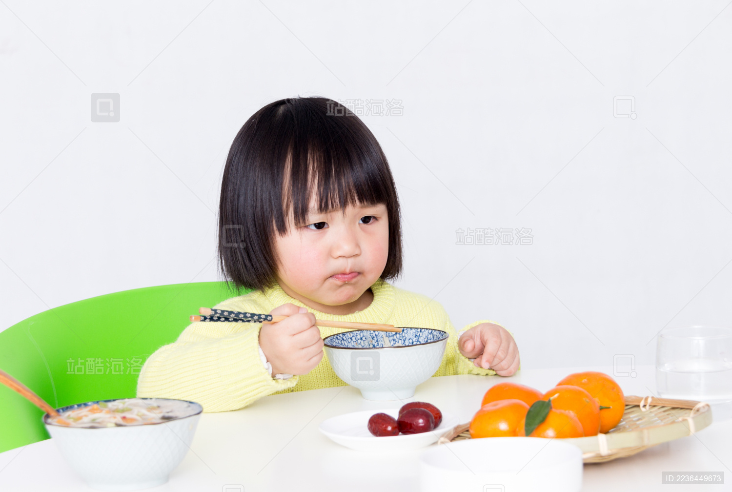 饭桌上自己乖乖吃饭的小女孩