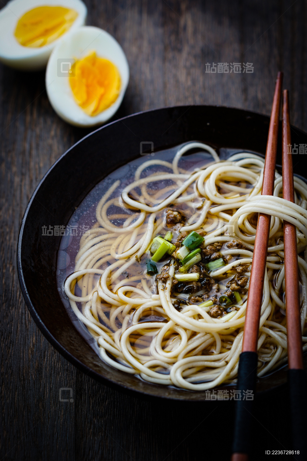 被挑出的亚洲中式面条放在筷子和陶碗上