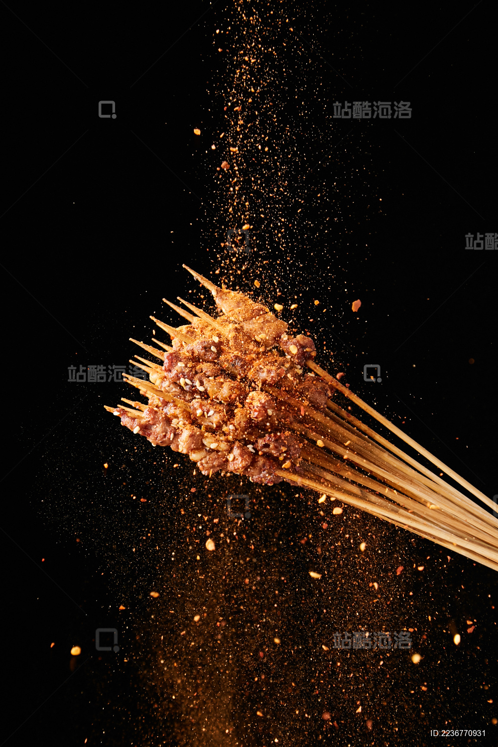 黑色背景上撒调料的烤羊肉串