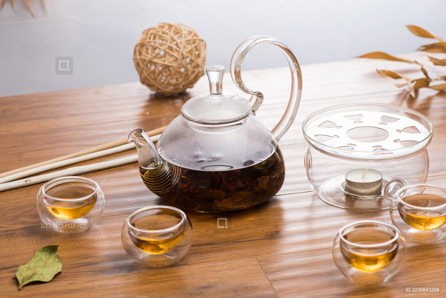 复古别致的透明玻璃茶壶和三个玻璃茶杯在原木色桌面上冲泡红茶场景