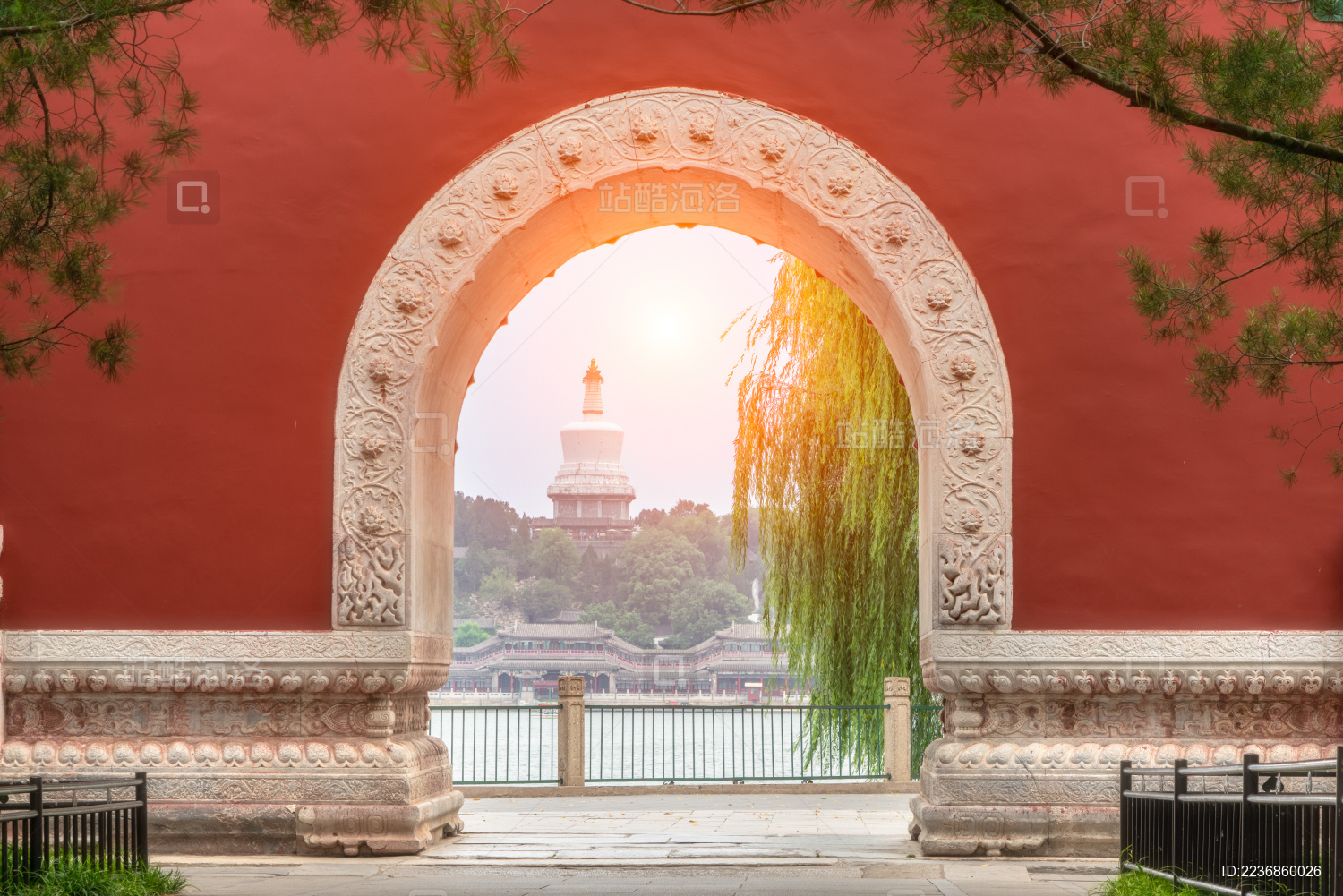 中国北京北海公园夕阳下红墙上的拱门里的白塔