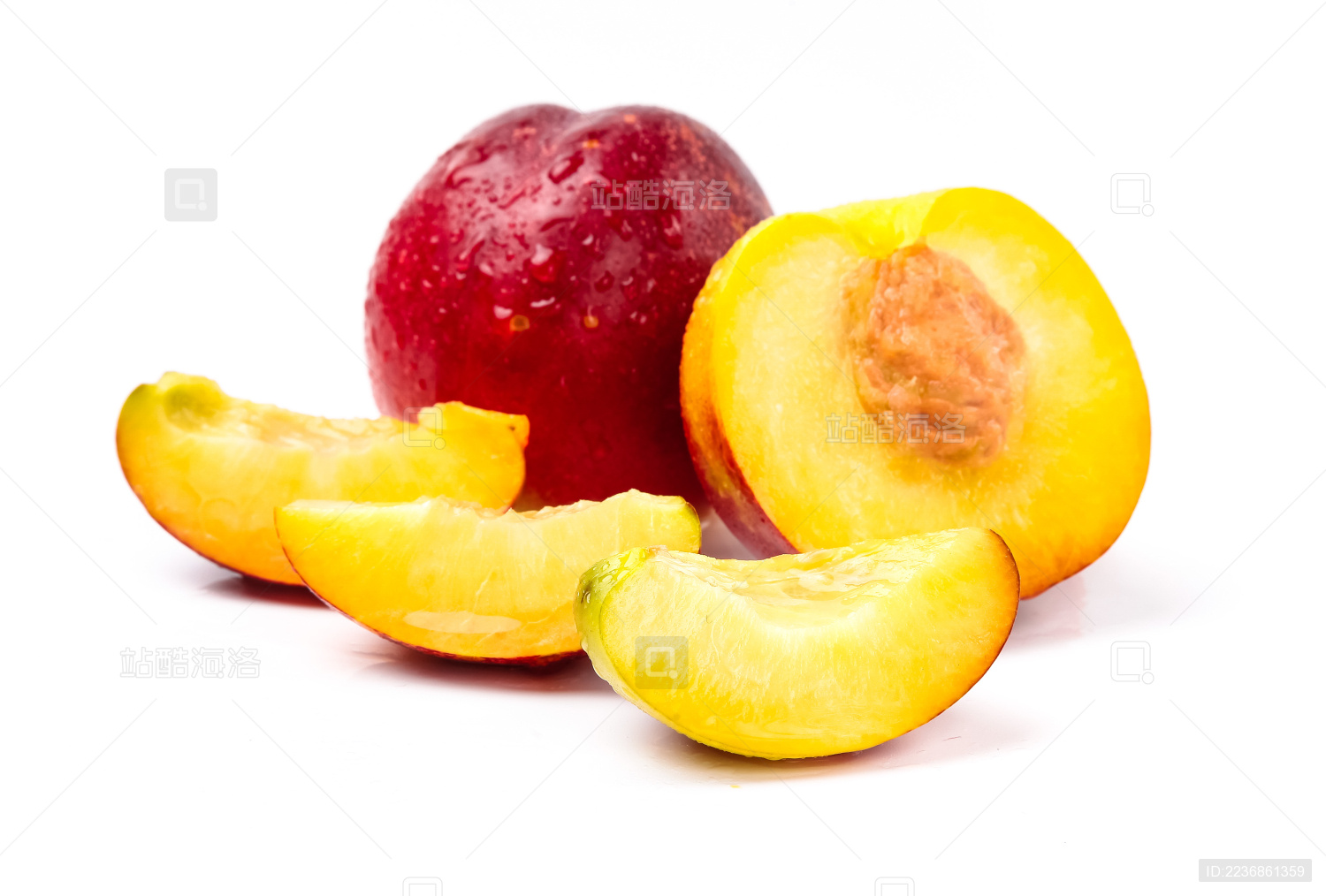白底上的一个完整的油桃前靠着一个切开的油桃 旁边有三块新鲜的油桃