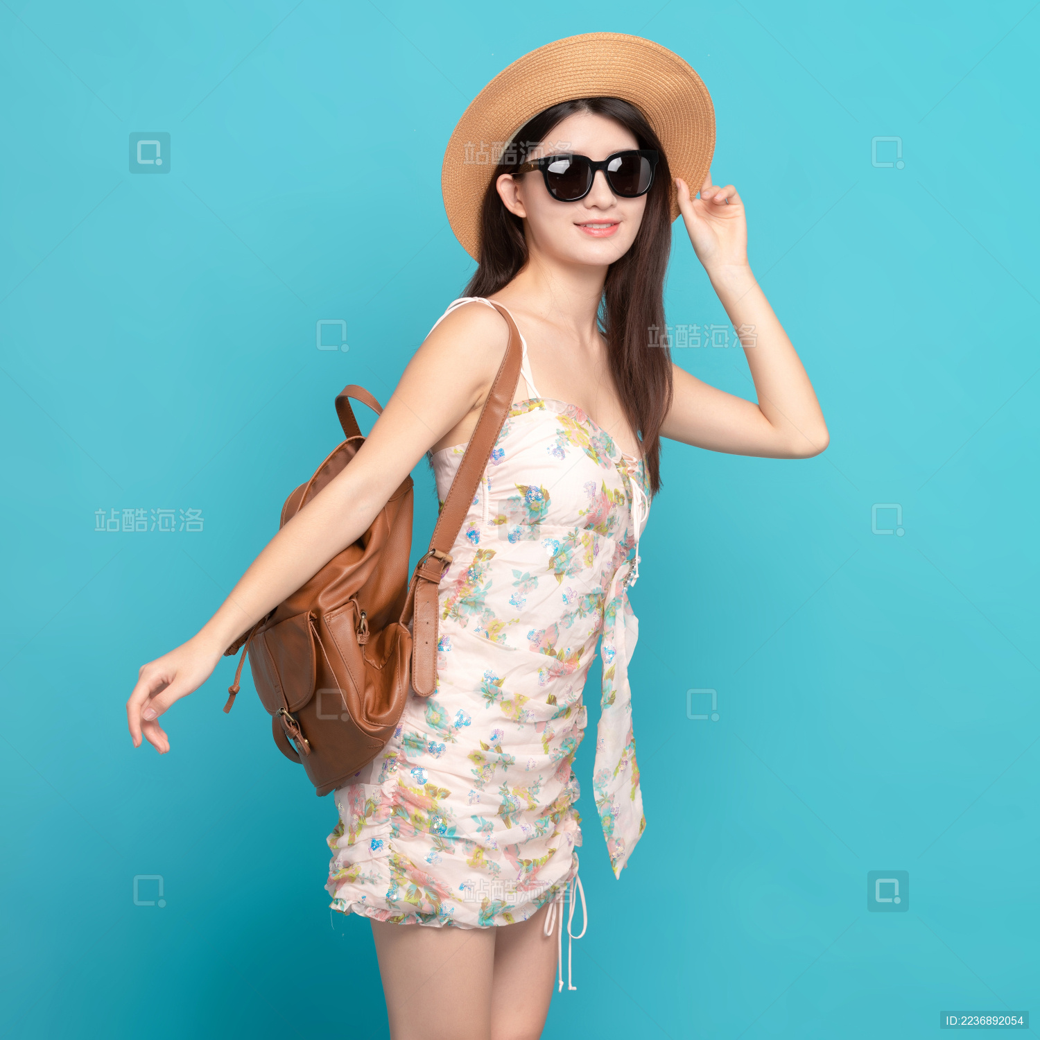 蓝色背景里 带着墨镜和帽子的美丽亚洲女孩