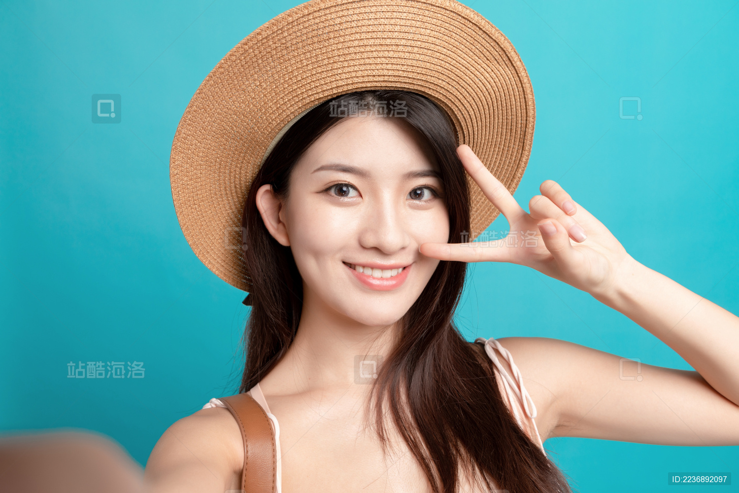 蓝色背景里 对着镜头正在自拍的东方美女