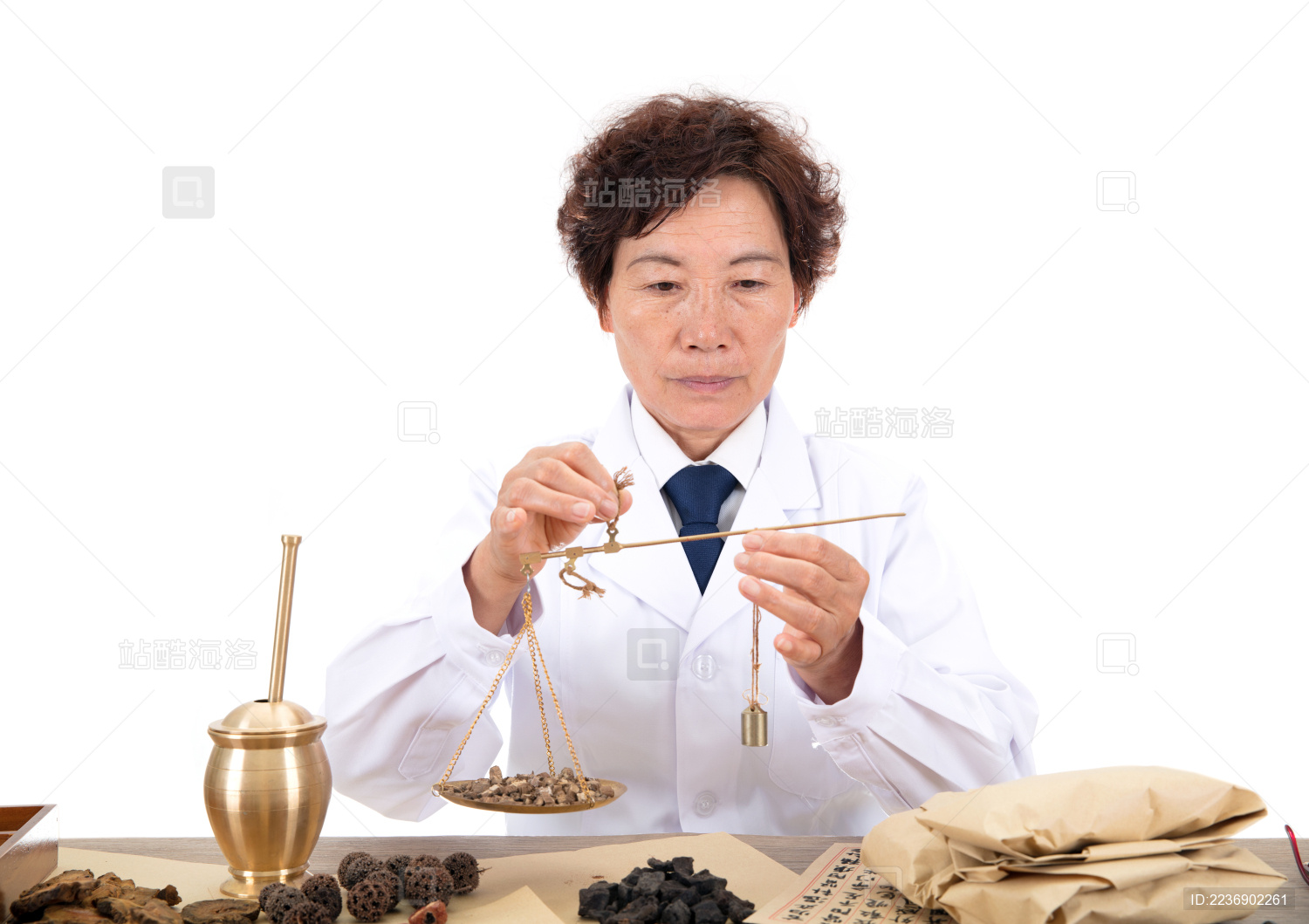 白背景前中国老中医正在配药