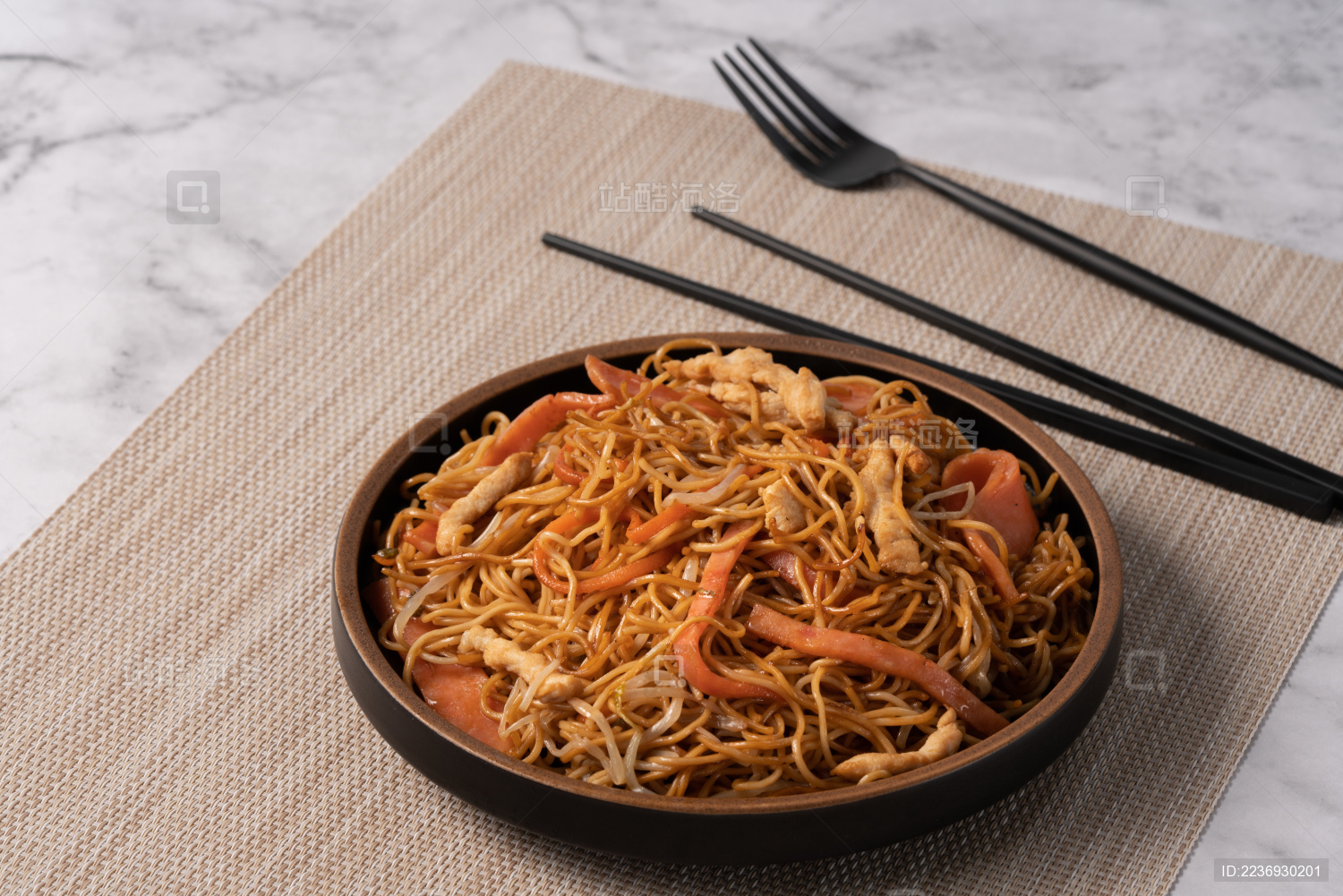 大理石桌面上的三丝炒面和旁边的筷子 叉子