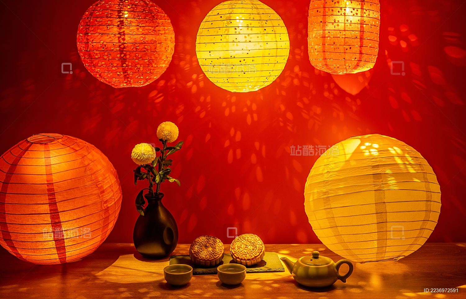 红色背景中彩色灯笼灯光下的中秋月饼和茶水