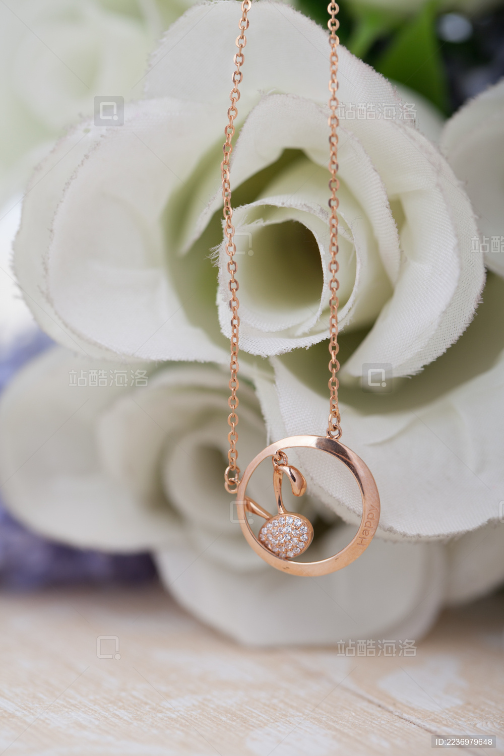 清新背景上随意摆放着的金项链吊坠