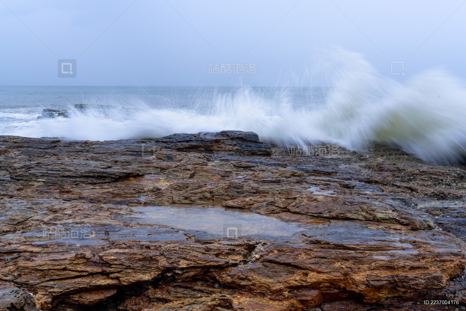蔚蓝大海上的浪花和海岸边的礁石