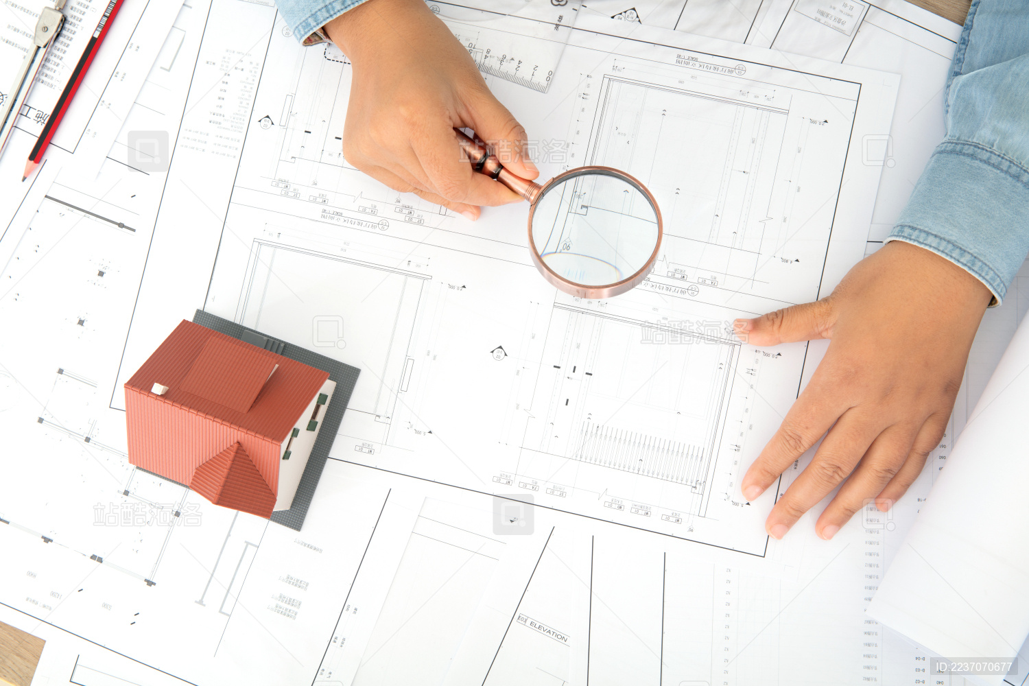 建筑设计师手拿放大镜观察施工图纸