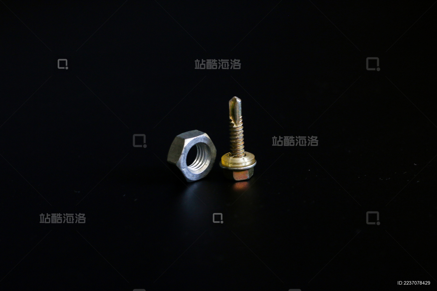 纯黑色背景板上的不锈钢螺丝螺母