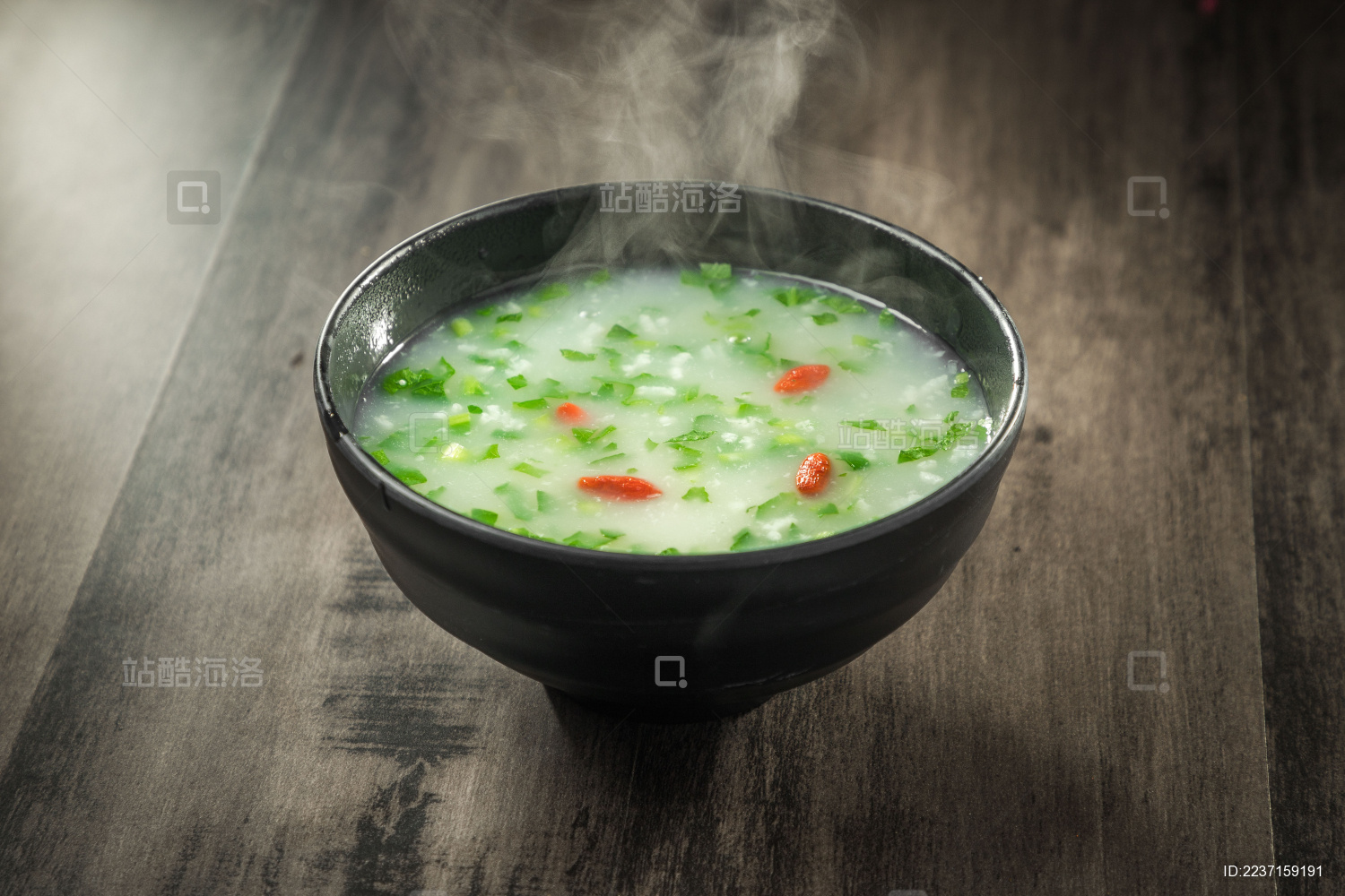 棕色木纹桌面上放着一份冒着热气的菜粥