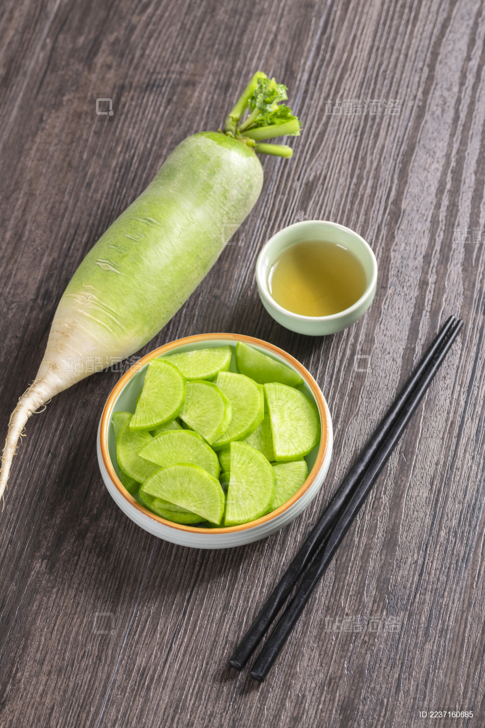 保健蔬菜青萝卜片盛放在盘子中摆放在桌面上