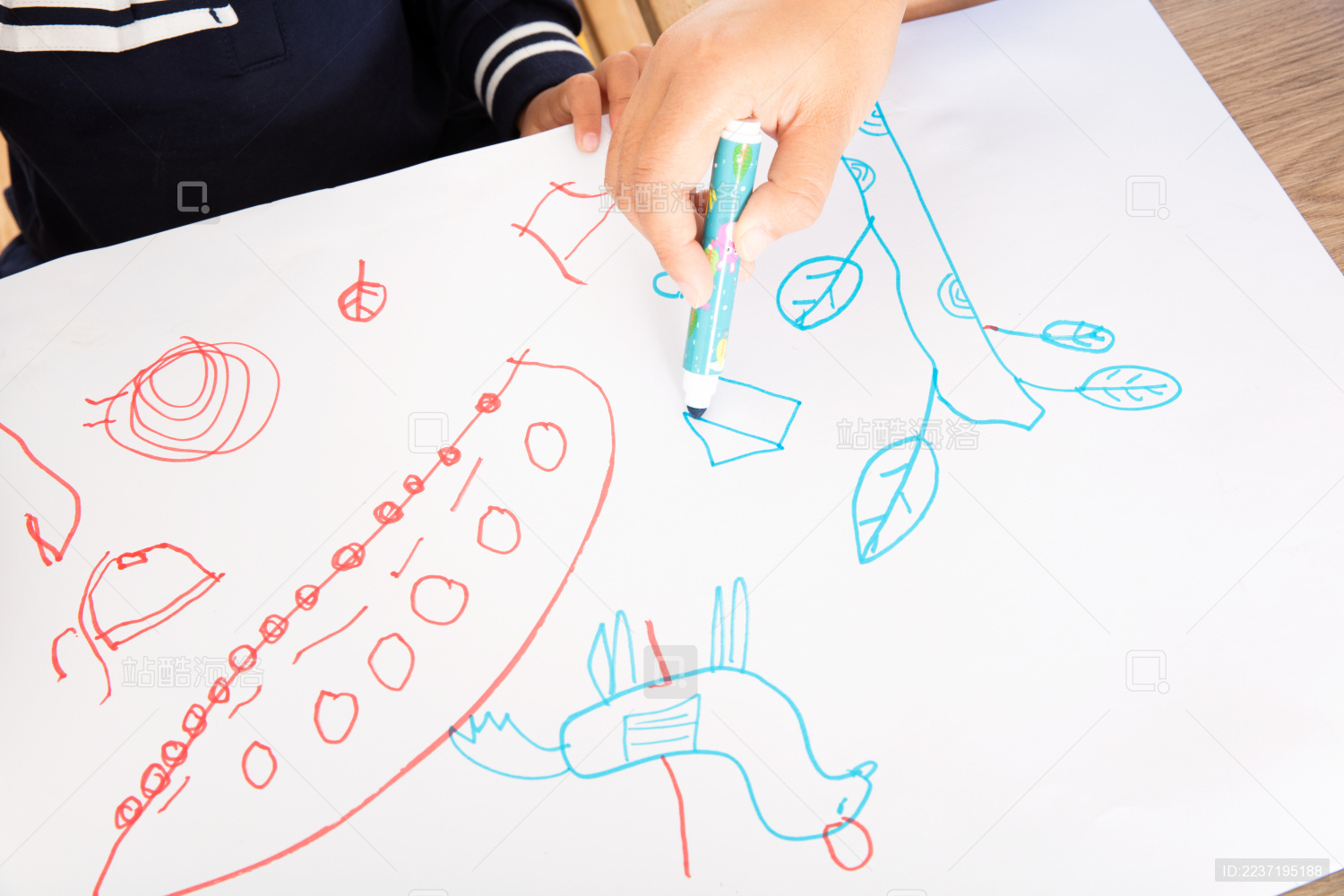 幼儿园的孩子在白纸上练习绘画