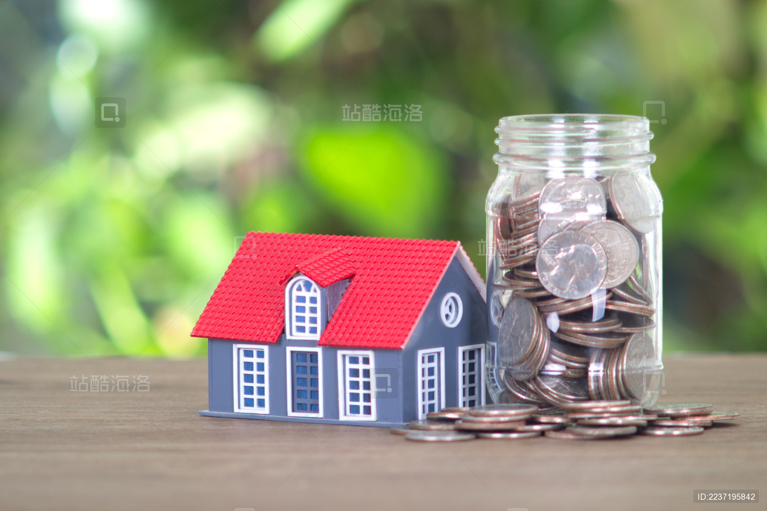 装满美元硬币的玻璃瓶和房子模型