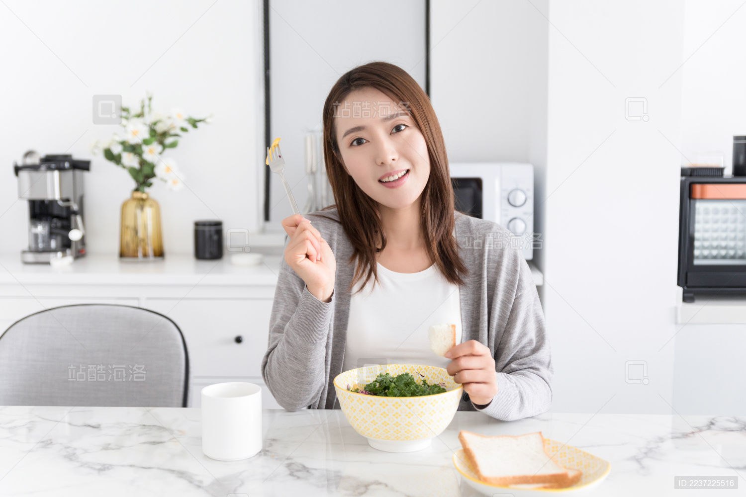 一名年轻女性在家吃健康早餐并举起叉子