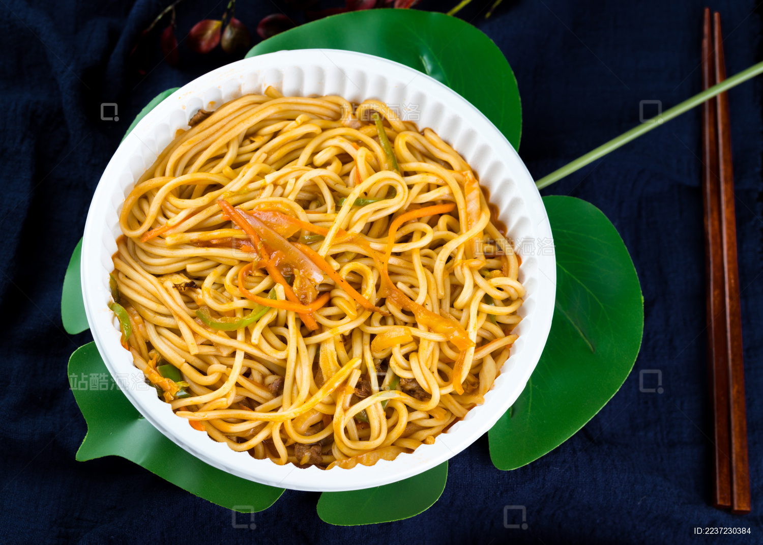 一个白色塑料碗装满炒面放着暗色背景上