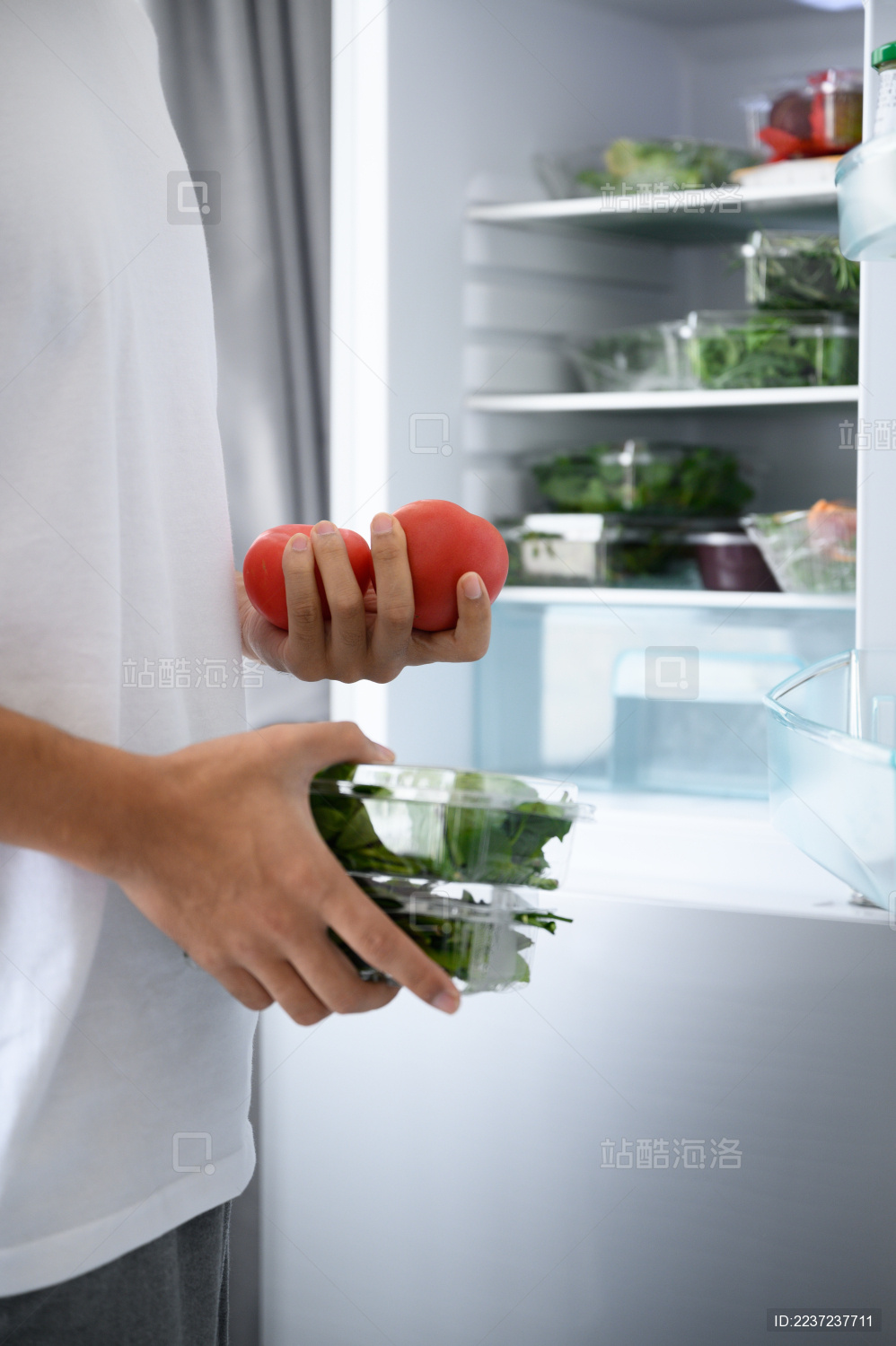 年轻亚洲男人从冰箱里拿食材