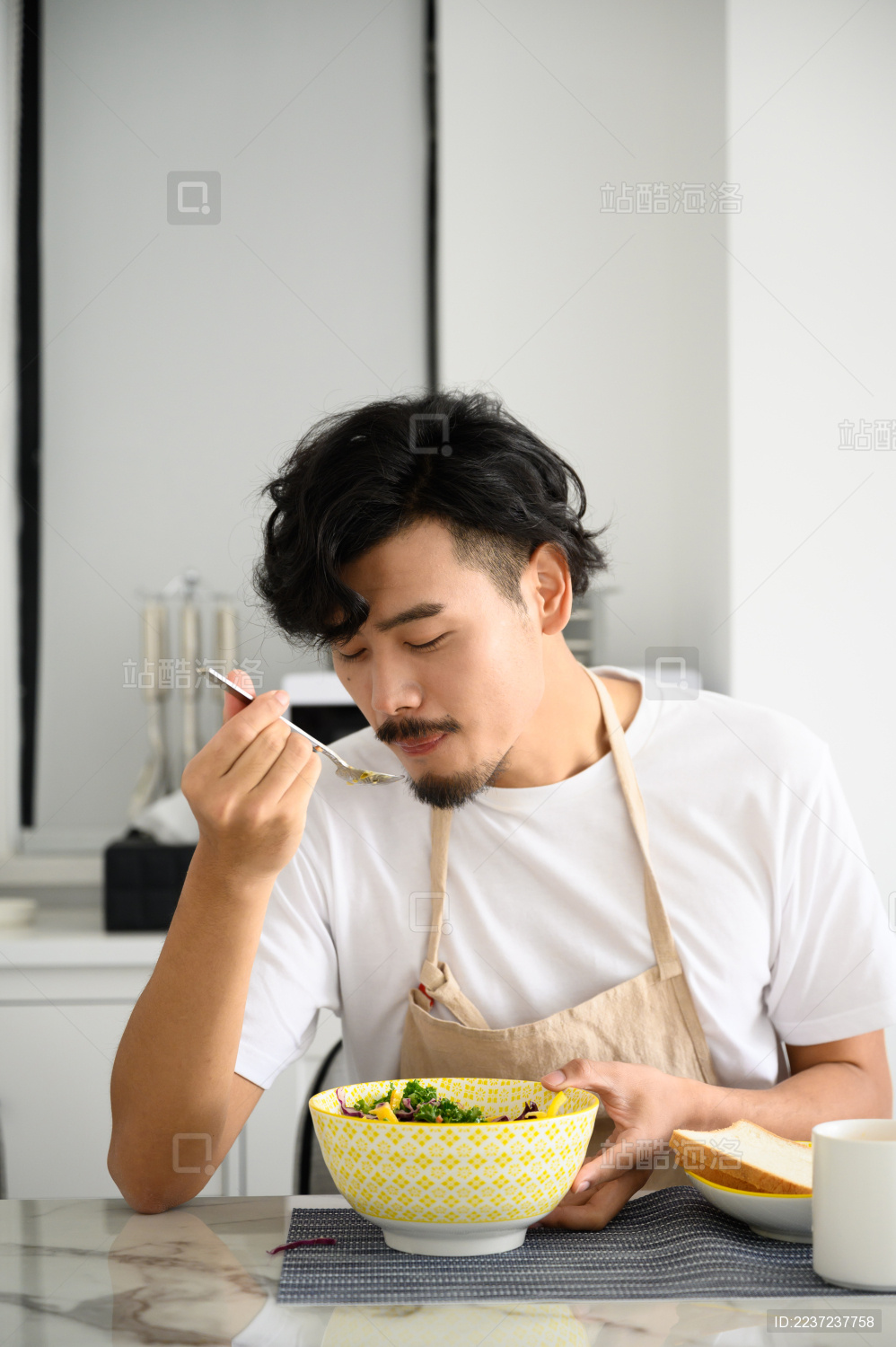 年轻亚洲男人在家吃早饭