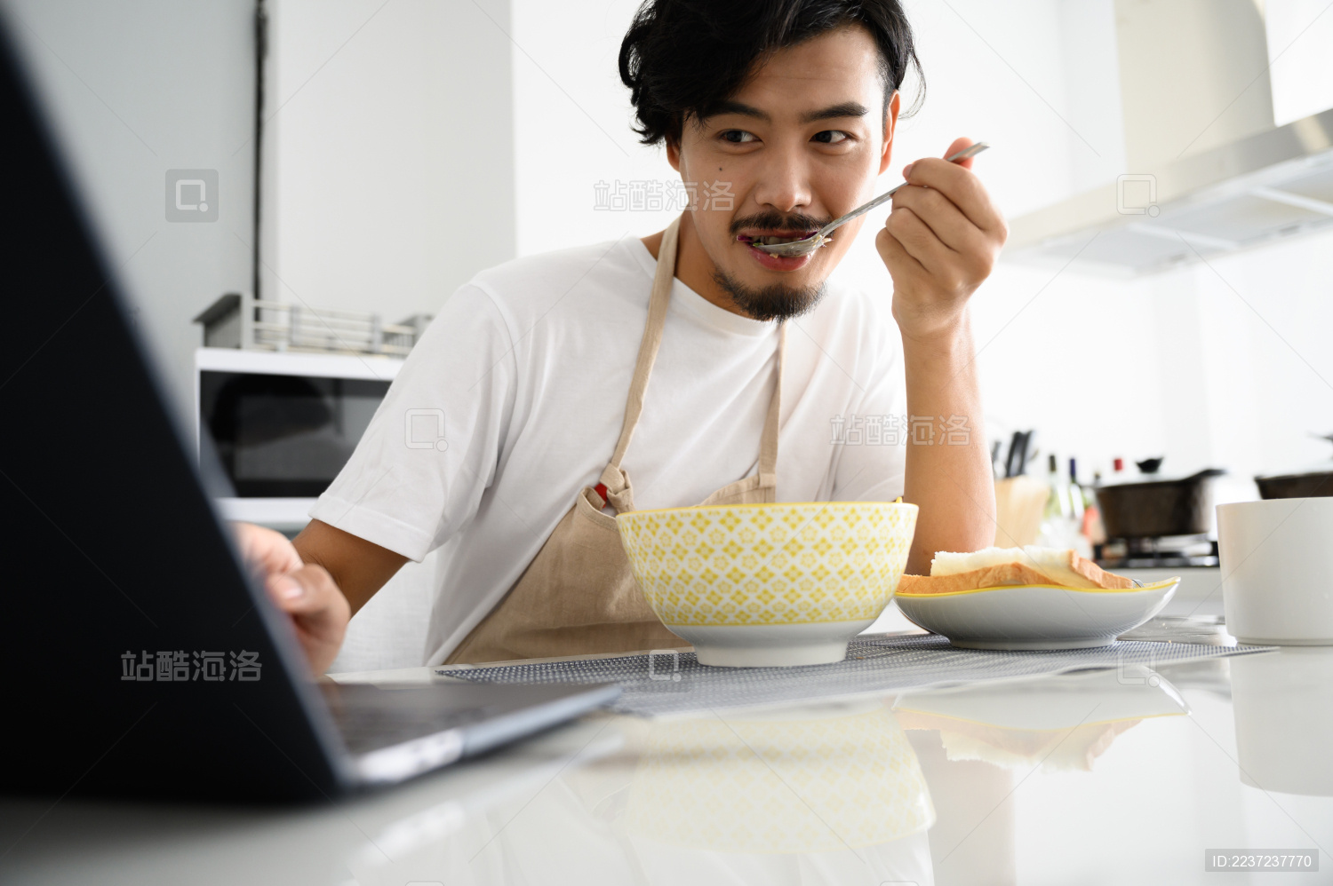 年轻亚洲男人在家吃早饭