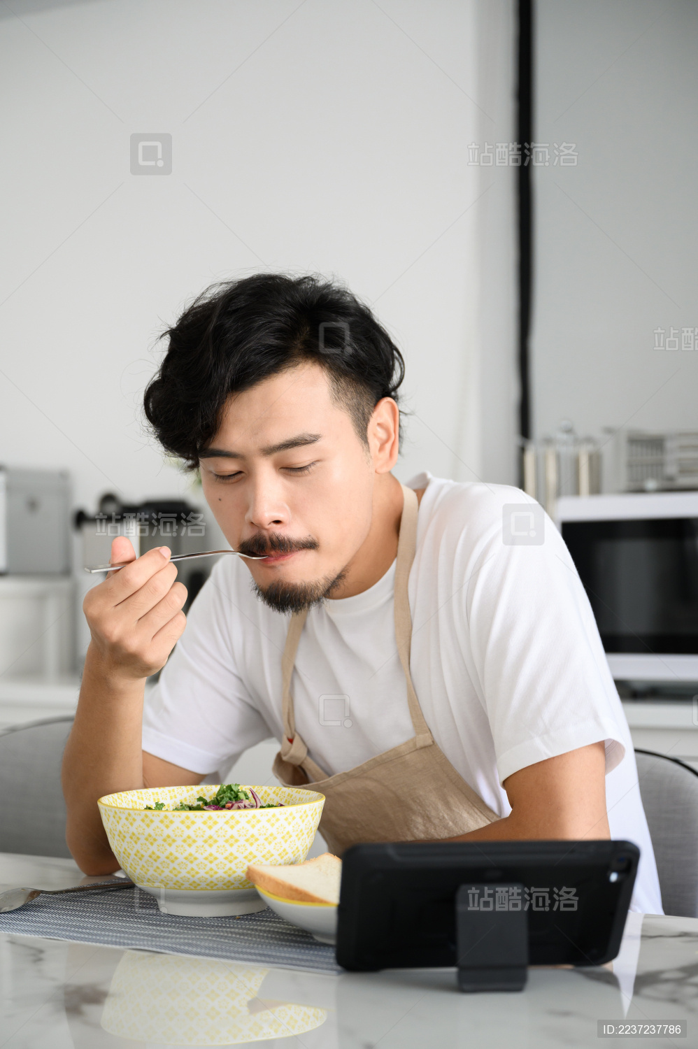 年轻亚洲男人在家吃早饭
