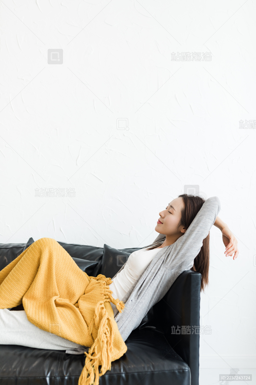 一个年轻女性半卧在客厅沙发上