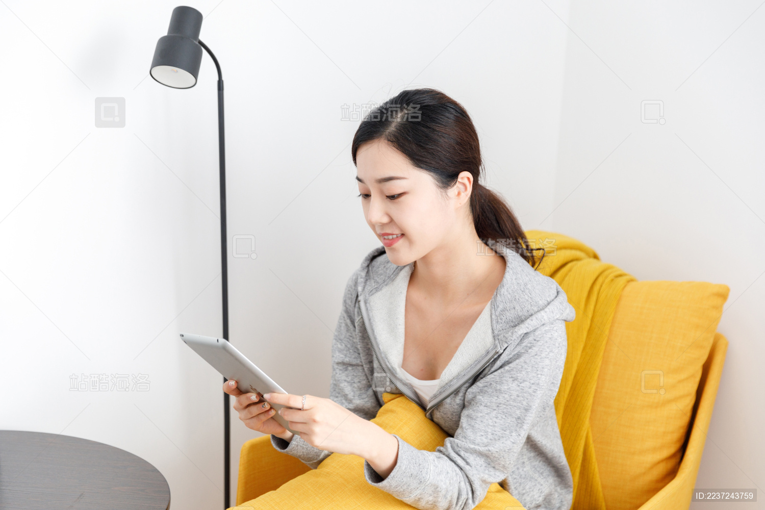 居家室内卧室使用平板电脑的女性
