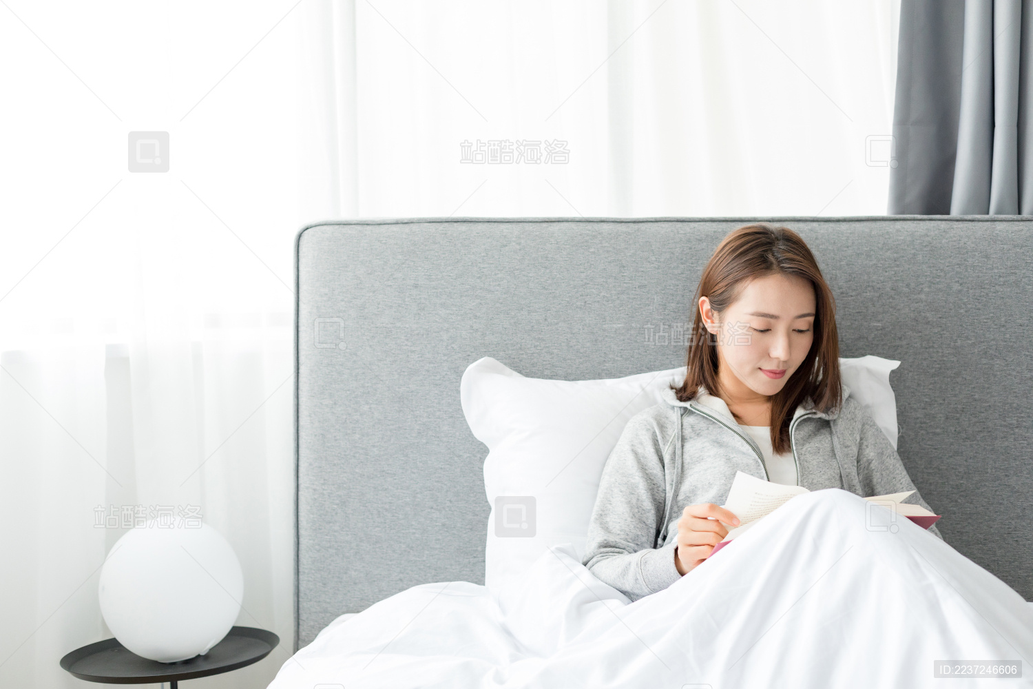 一个年轻女士在卧室靠着看书