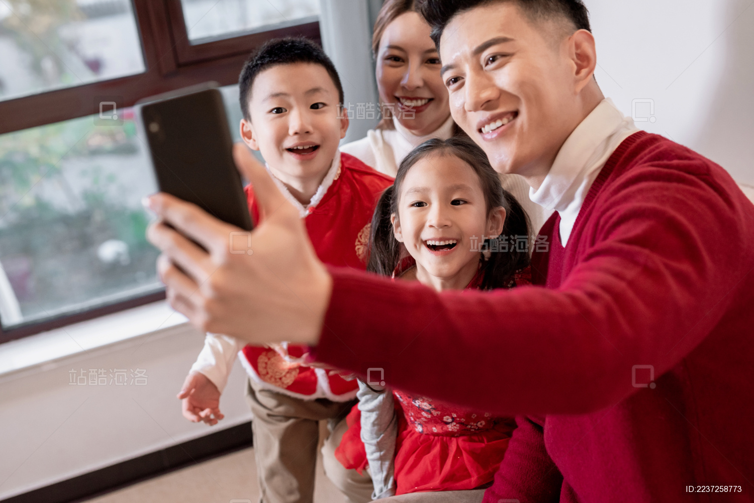 一个年轻的中国家庭开心的在一起用电话视频聊