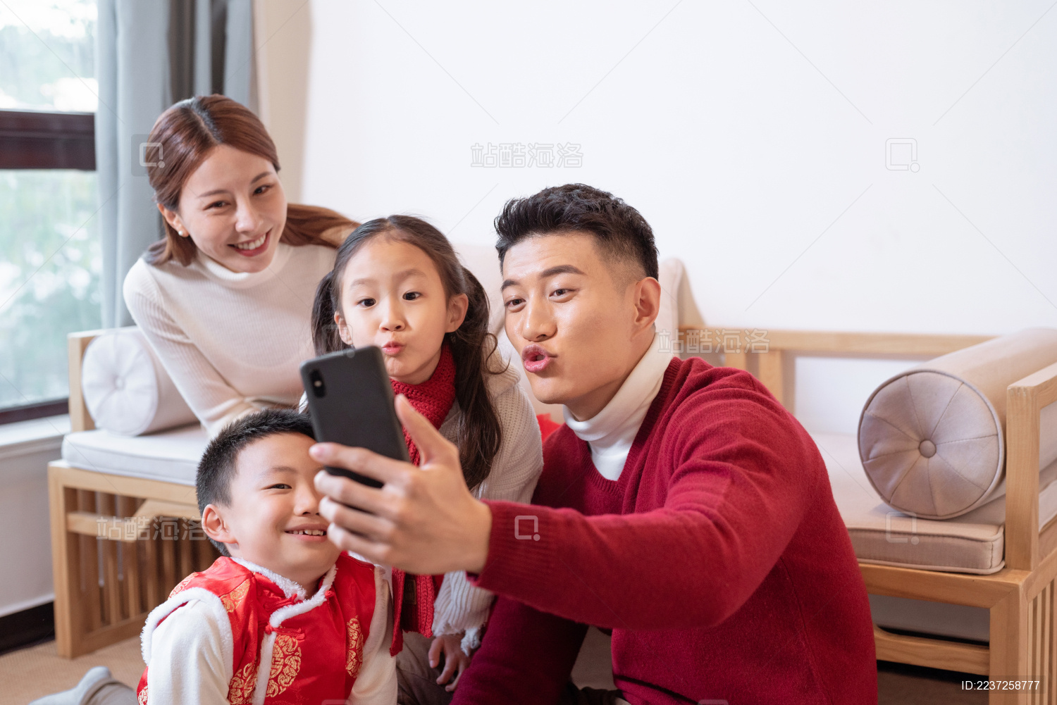 一个年轻的中国家庭开心的在一起用电话视频聊