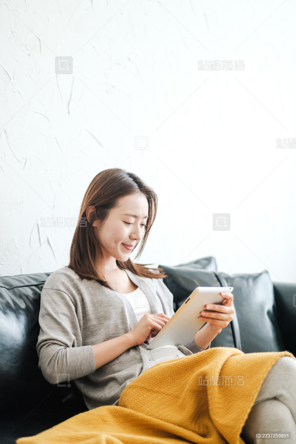 漂亮女孩在沙发盖毯子看书