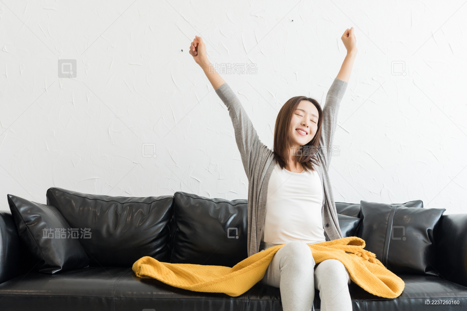 年轻女性坐在客厅沙发上拉筋伸展身体