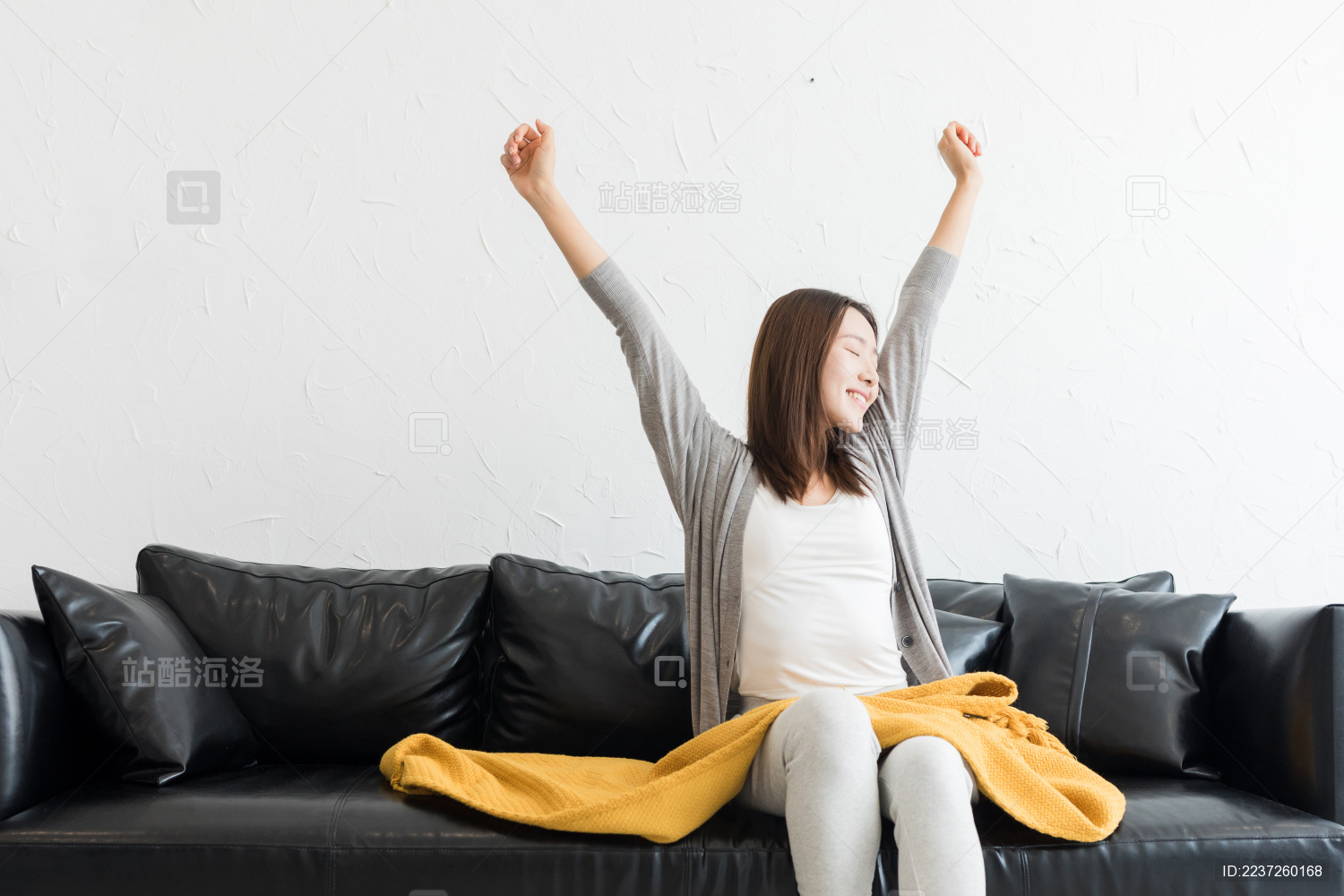年轻女性坐在客厅沙发上拉筋伸展身体