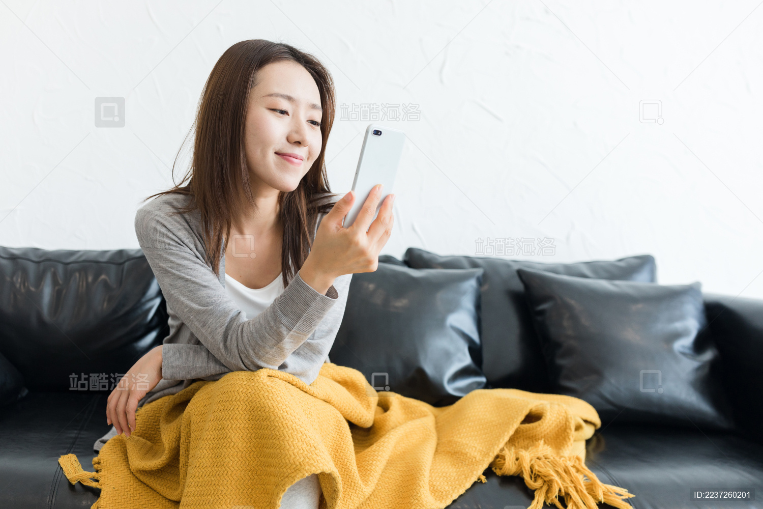 一个年轻女性坐在沙发上看手机