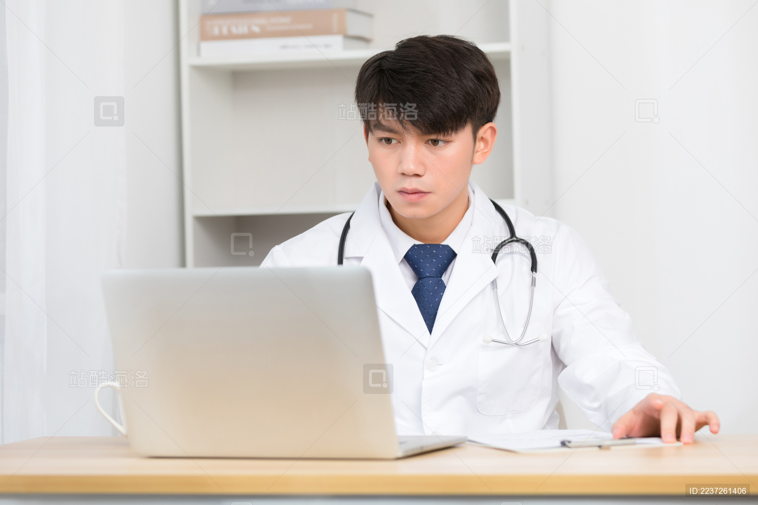 坐在办公室里正在工作的亚洲男医生