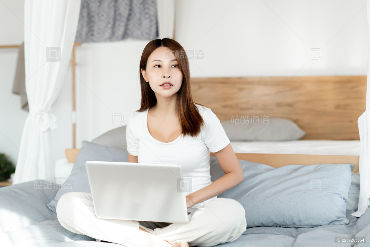 一位年轻女性在沙发上使用笔记本电脑