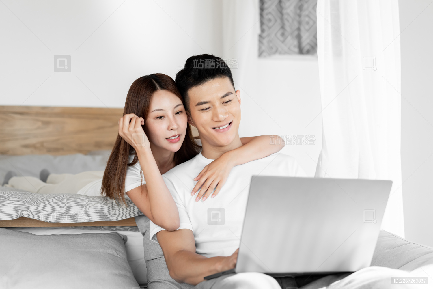 一对情侣在床上开心的使用平板电脑