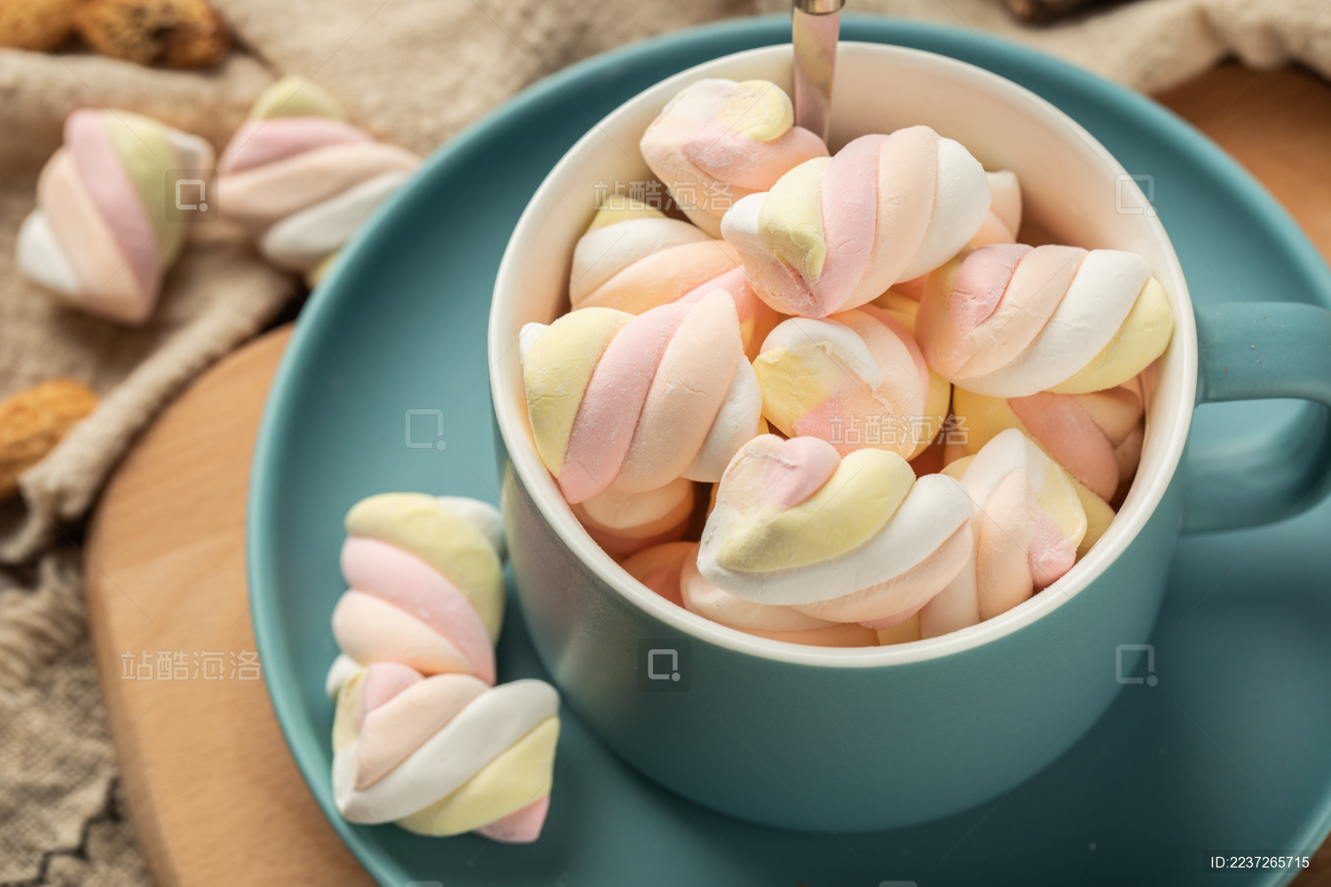 木质背景上蓝色的陶瓷杯与彩色棉花糖