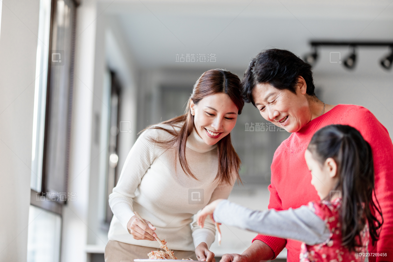 奶奶和妈妈在教小女孩包饺子