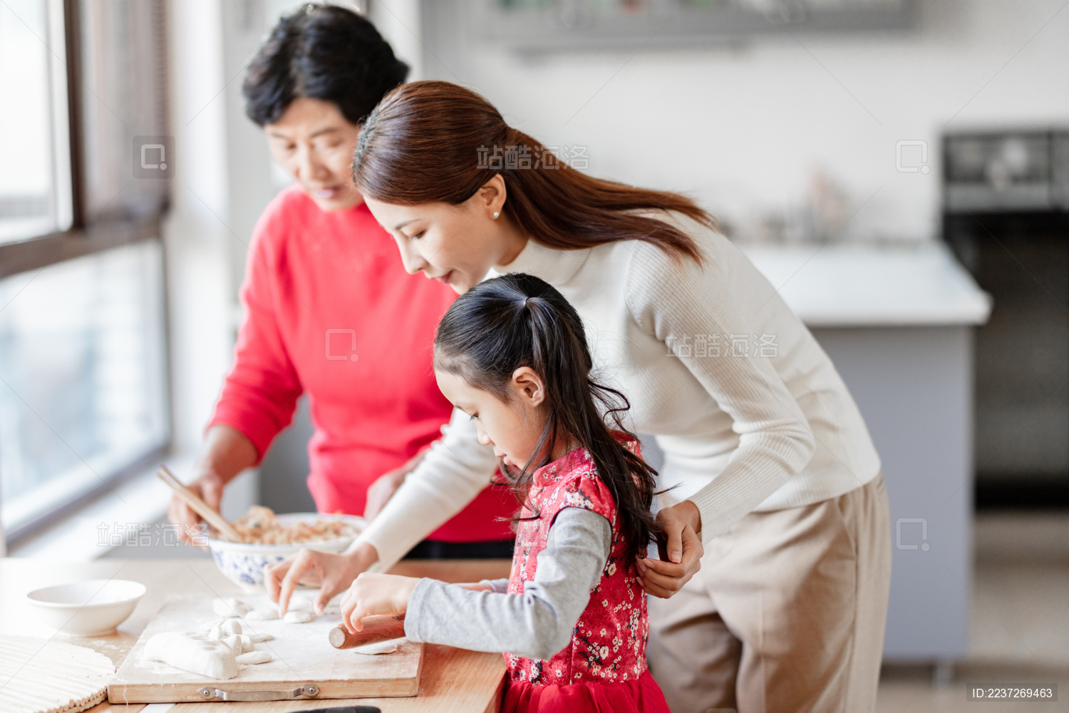 奶奶和妈妈在教小女孩包饺子